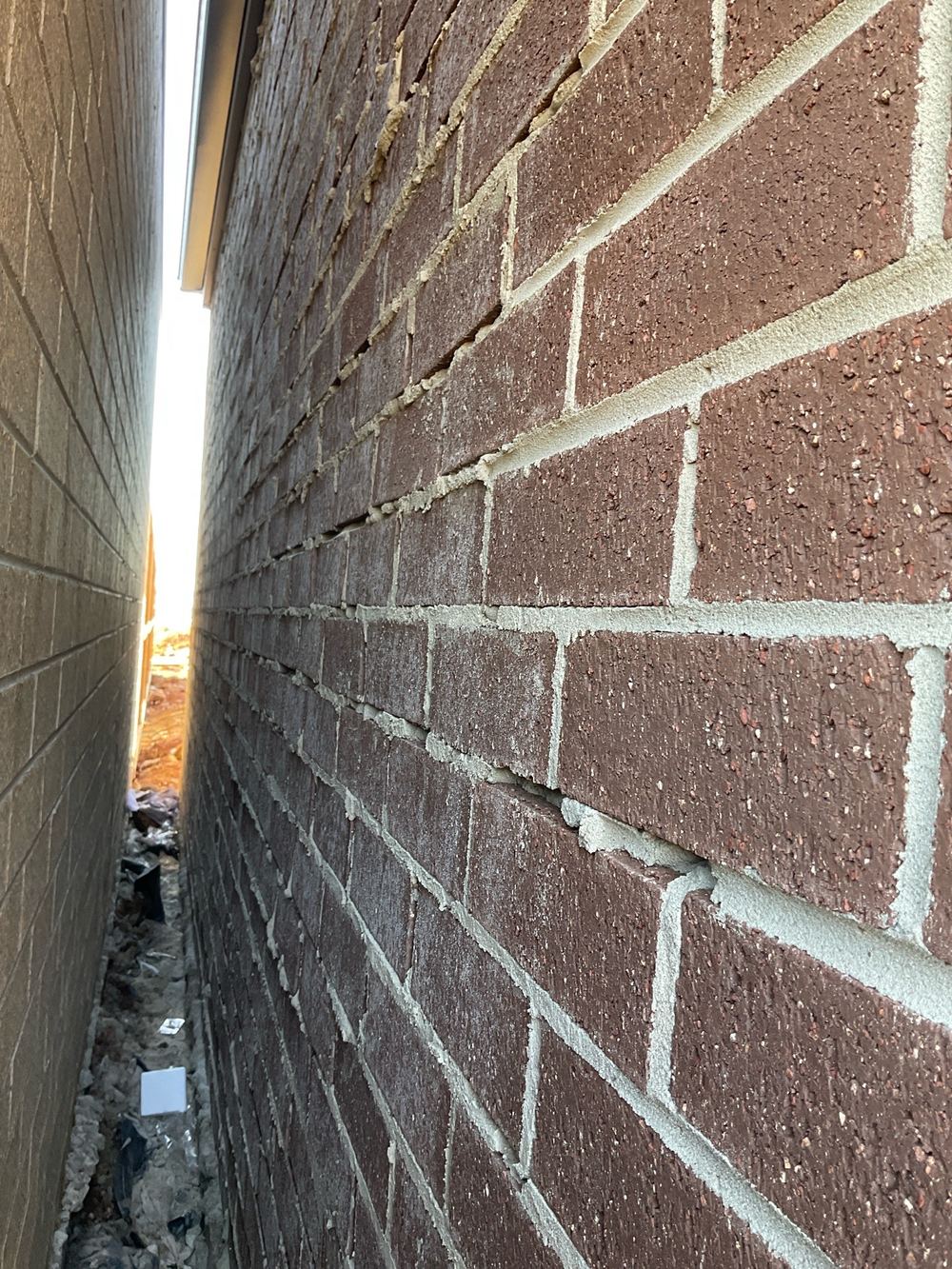Mortar joints with holes that let water into the brick cavity, found during a pre-handover inspection in Aintree