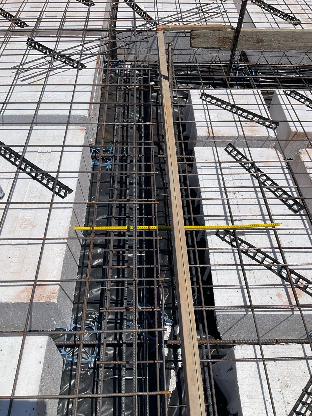 Extra top and bottom bars missing from a load-bearing rib wider than the engineering allows, found during a slab pre-pour inspection in Aintree